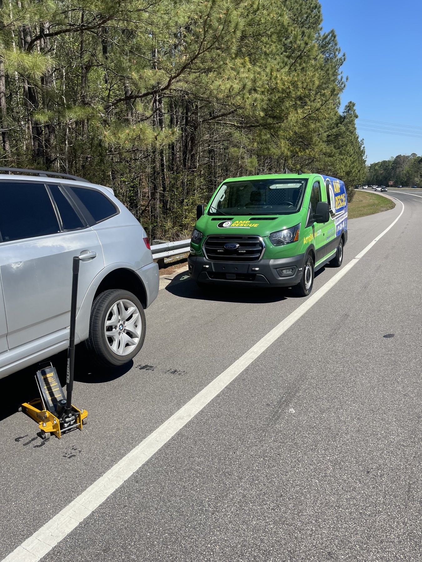 Amp Rescue mobile tire service helping a driver with a flat tire on a North Carolina roadside